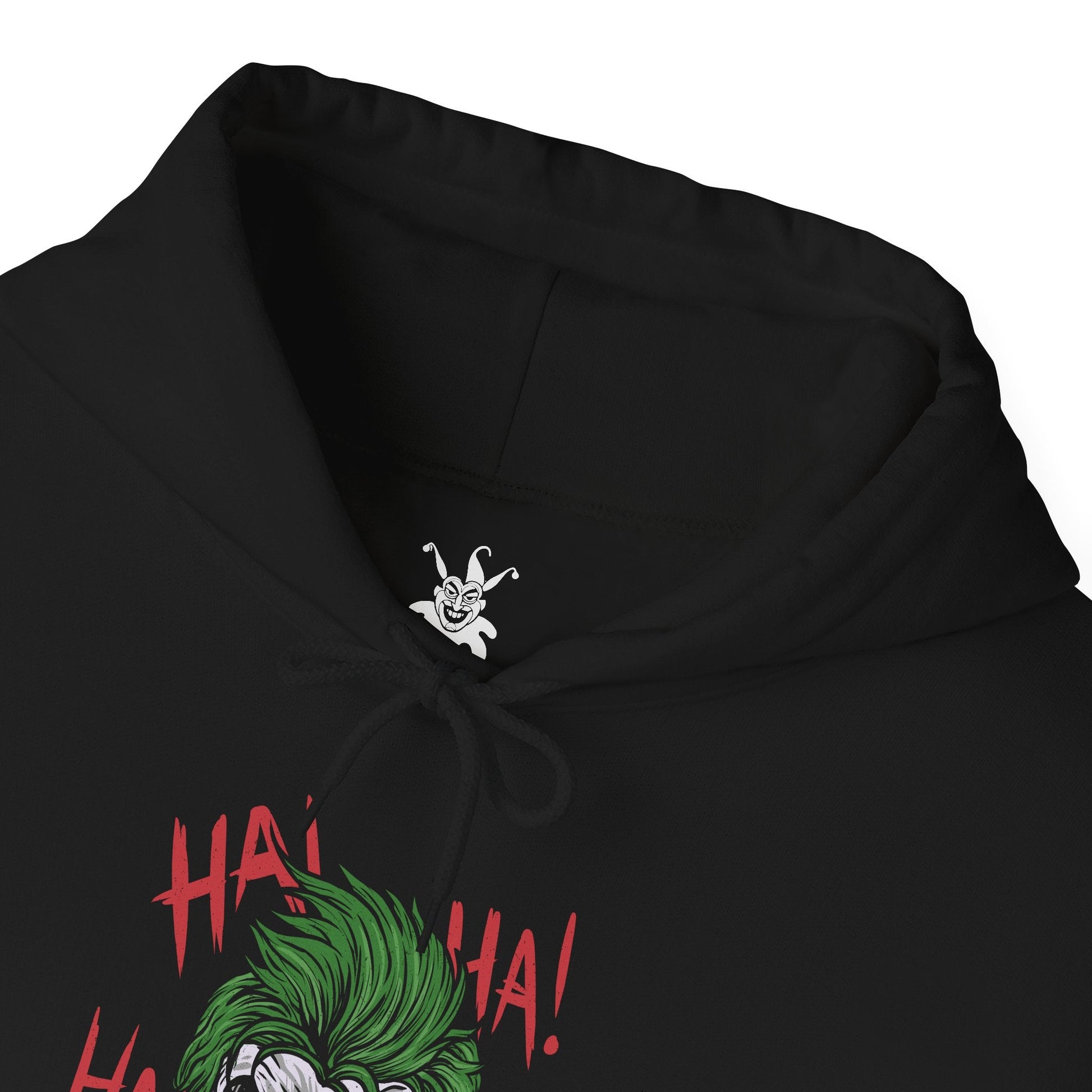Folded Hooded Sweatshirt of the Joker and Harley Quinn seated atop a pile of stolen cash and broken carnival props beneath neon lights. Harley’s colorful outfit contrasts with the Joker’s eerie purple suit as confetti and smoke swirl through the air. The composition emphasizes comic-book chaos, psychological manipulation, and the unforgettable partnership between Gotham’s Clown Prince of Crime and his equally unpredictable accomplice.
