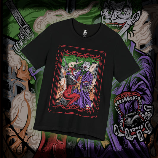 Thumbnail of a T-Shirt design of the Joker and Harley Quinn from DC Comics, standing amid a rain-soaked Gotham alley as playing cards, graffiti, and chaotic laughter surround them. The Joker’s sinister grin contrasts with Harley’s mischievous smile as she twirls her oversized mallet. The design captures their unpredictable partnership, anarchic romance, and the dangerous chemistry that has made them one of comic history’s most iconic villain duos.