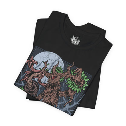 Image 5 of a T-shirt artwork depicting Trevenant standing deep within a dark Kalos forest, its wooden body twisted and jagged as glowing red eyes pierce through the fog. Shadowy roots spread across the ground while faint ghostly wisps swirl around its limbs. The design captures Trevenant’s role as a vengeful guardian Pokémon, embodying haunted woods, restless spirits, and ancient forest curses.